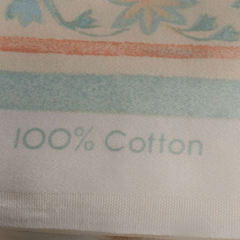 Texten 100% Cotton tryckt på tygkanten