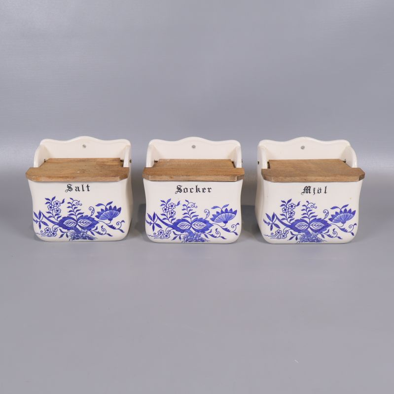 Tre keramiska kryddburkar med blå blomdekor och trälock