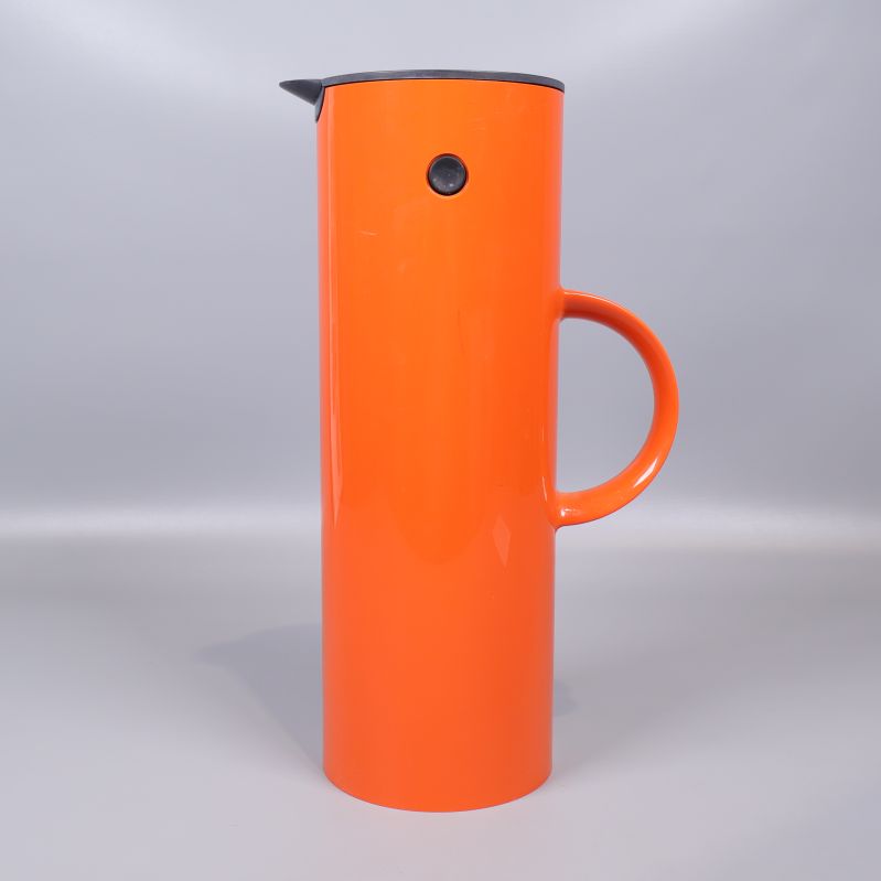 Sidan av termos med tydlig orange färg och svart knapp