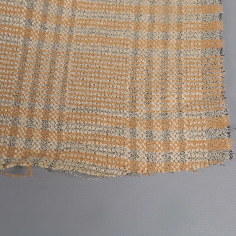 Närbild på tygkant med fransar och rutigt mönster