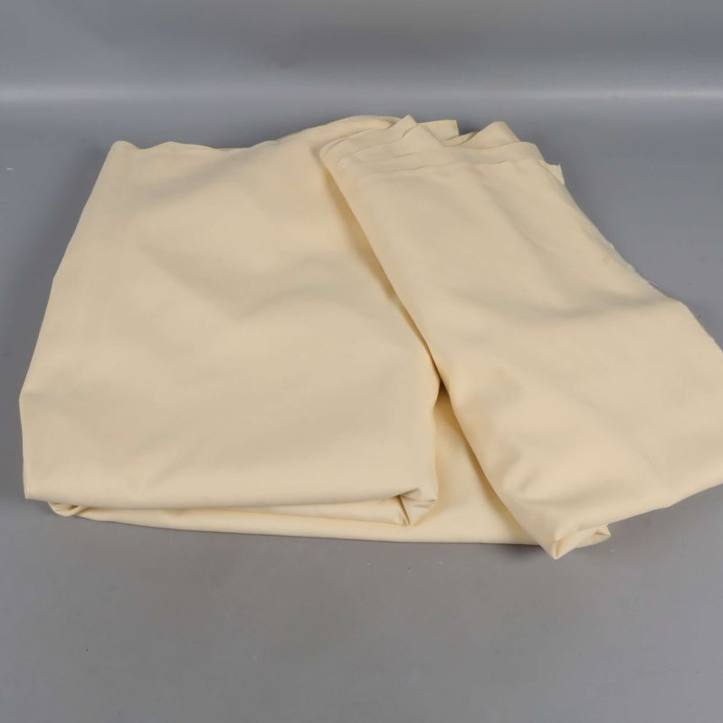 Beige tygstycke delvis utvecklat på grå yta