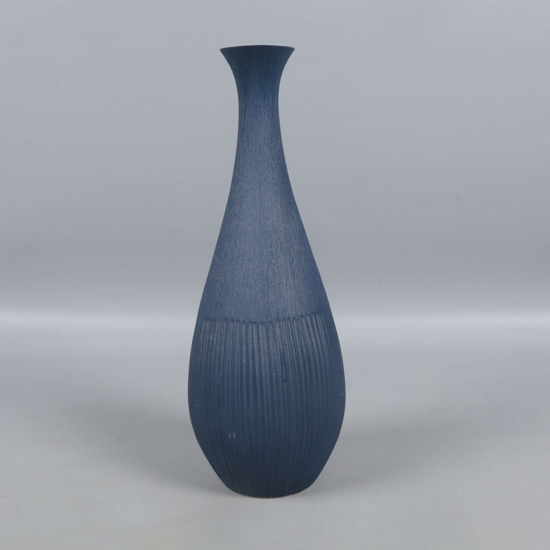 Vas i blått sedd rakt framifrån mot grå bakgrund