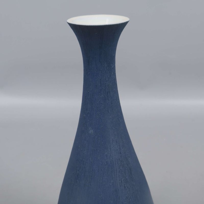 Närbild på vasens hals med matt blå yta