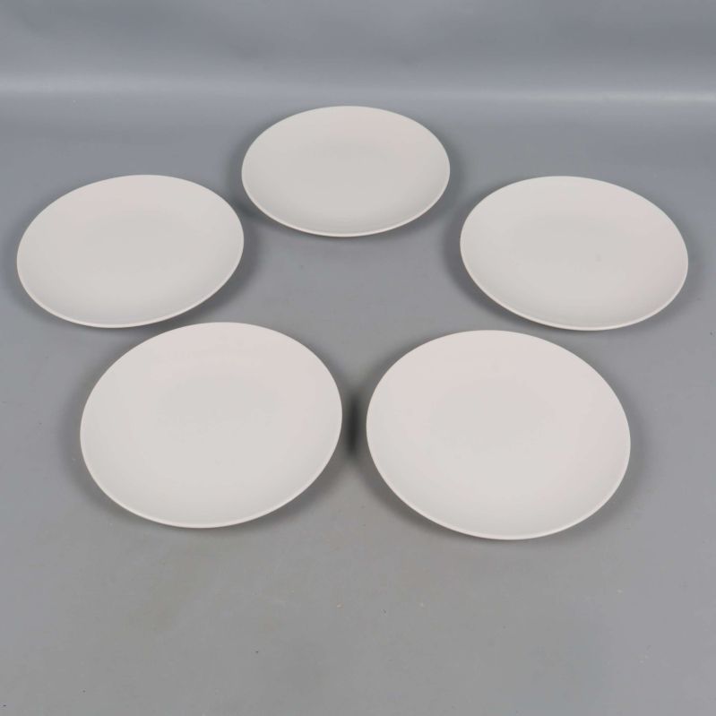 Fem vita tallrikar placerade i en cirkel