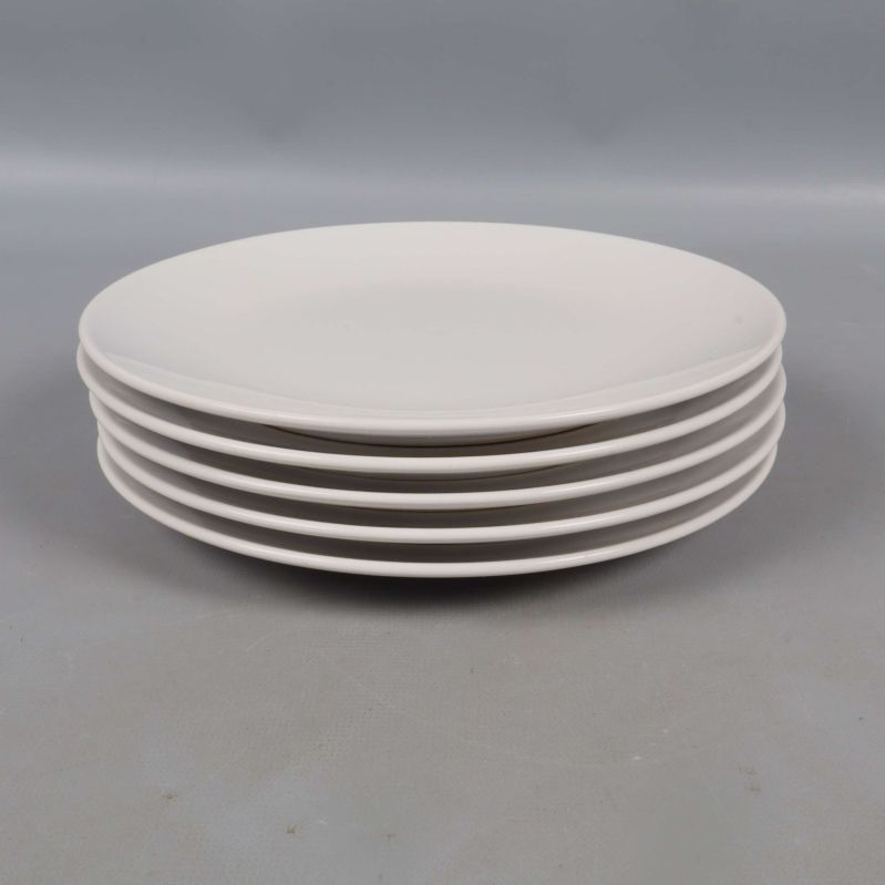 Fem vita tallrikar staplade med sidan mot kameran