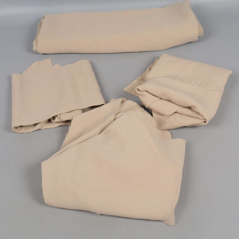 Fyra delar av beige tyg liggande på grå yta