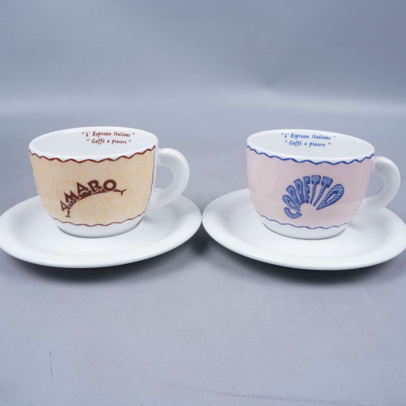 Två espressokoppar med motiv på fat framifrån