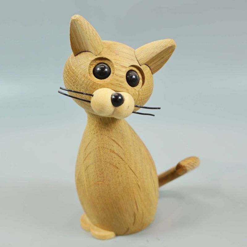 Träfigur av katt med stora svarta ögon och morrhår