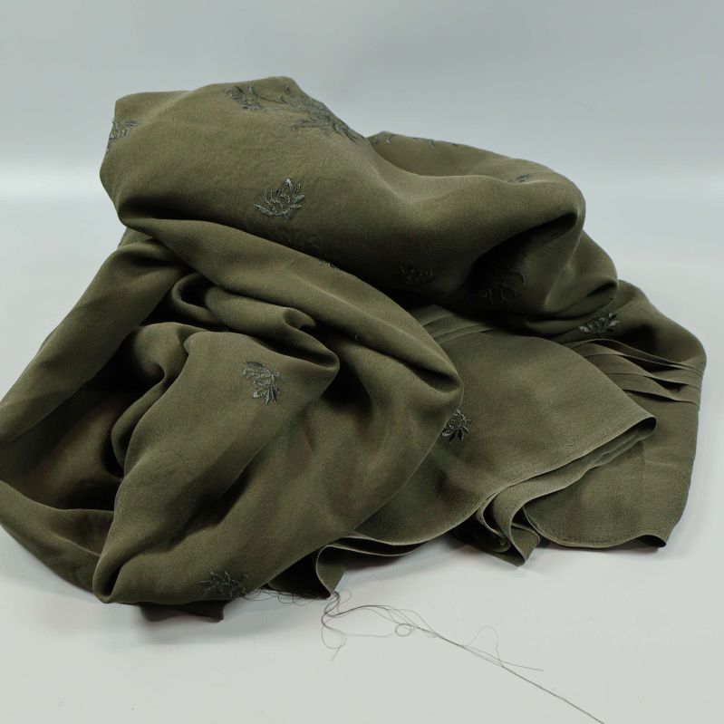 Mörkgrönt, mjukt tygstycke slarvigt draperat