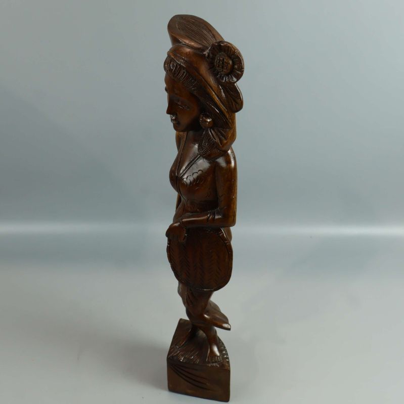 Profilbild av tribalinspirerad träskulptur på ljus bakgrund
