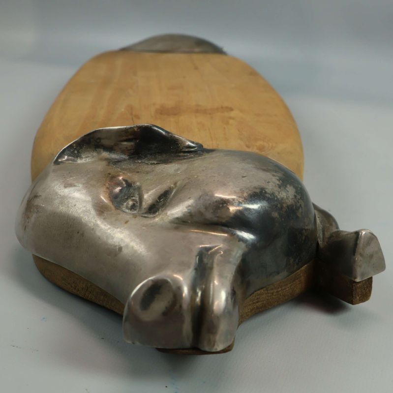 Närbild av metallgrishuvud på skärbrädans ena ände
