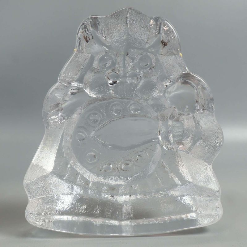 Glasfigur av samurai rakt bakifrån mot ljus bakgrund