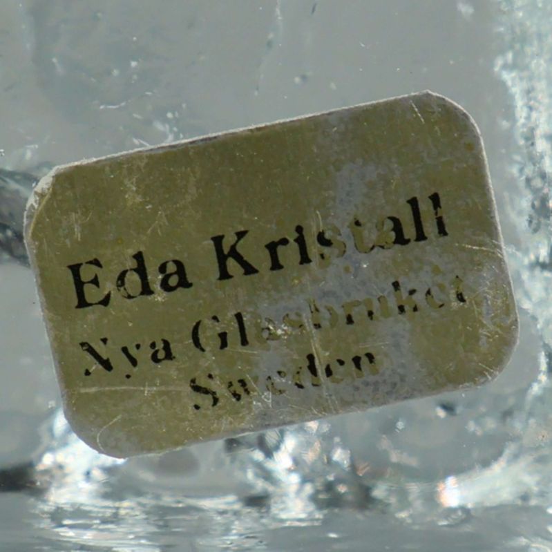 Närbild på etikett med texten Eda Kristall Nya Glasbruket Sweden