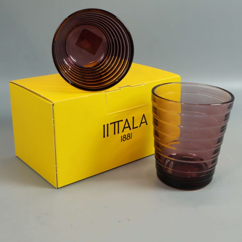 Lila glas och gul Iittala-box med glas ovanpå