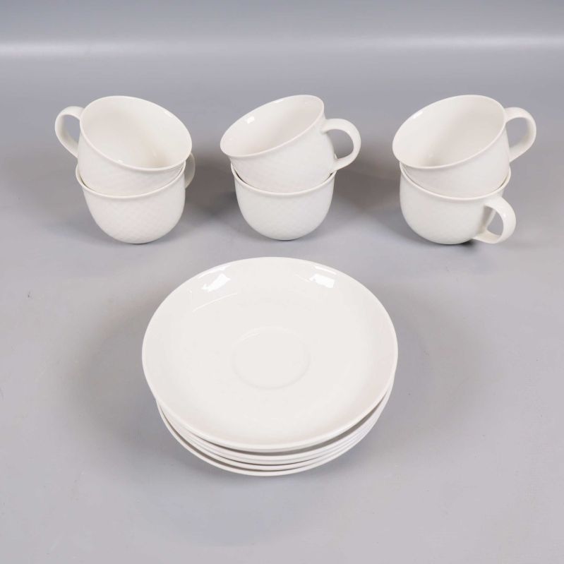 Sex vita kaffekoppar med tillhörande fat staplade