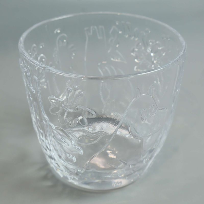 Närbild på ett genomskinligt glas med Muminmotiv