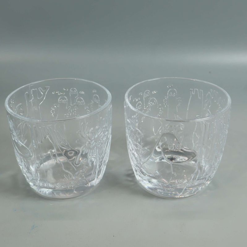 Två genomskinliga glas med muminmotiv framifrån