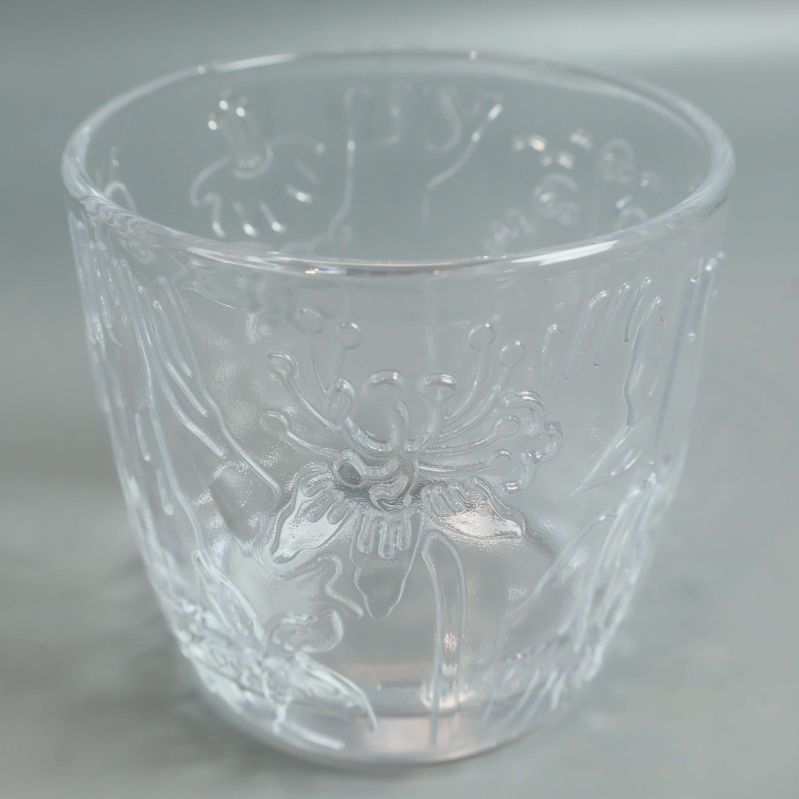 Närbild på glas med blomliknande motiv i relief