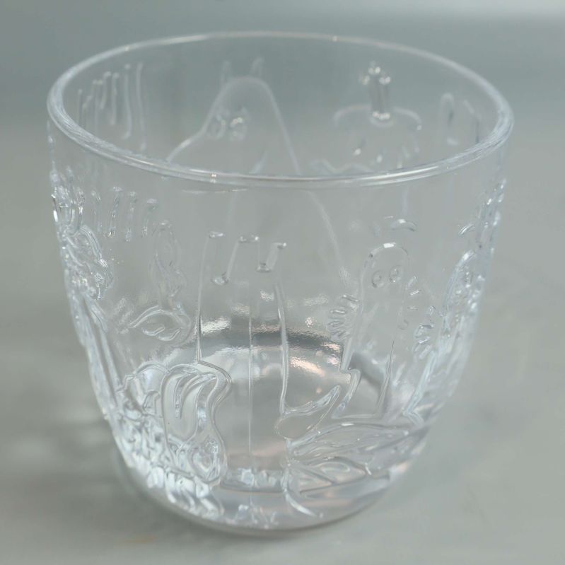 Närbild av Mumin-glas med tydligt motiv och rund form