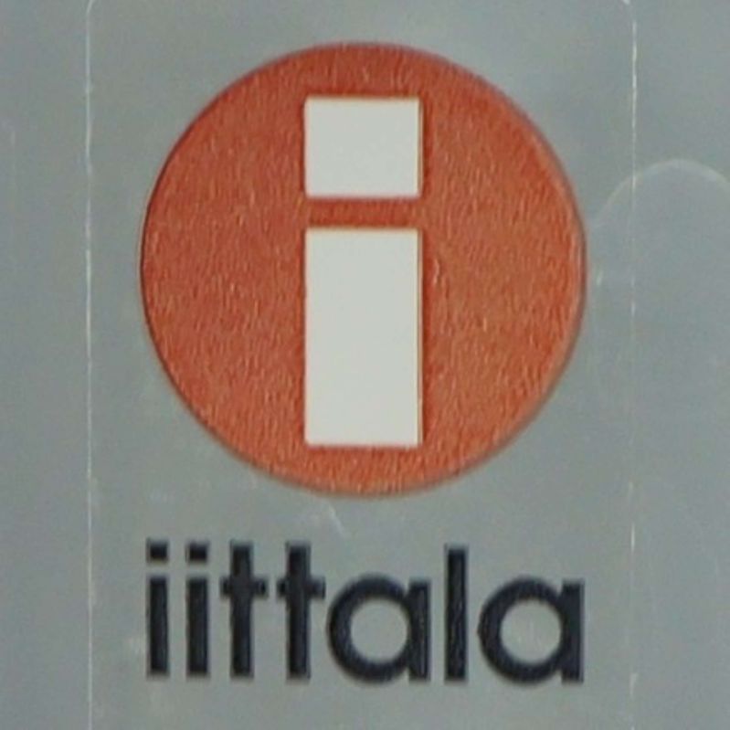 Närbild på Iittala logotyp i röd och vit på glaset