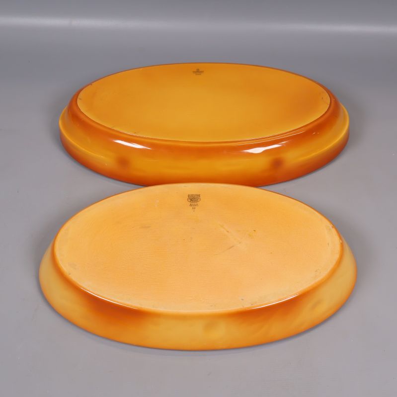 Baksidan på två keramiska fat med orange färg