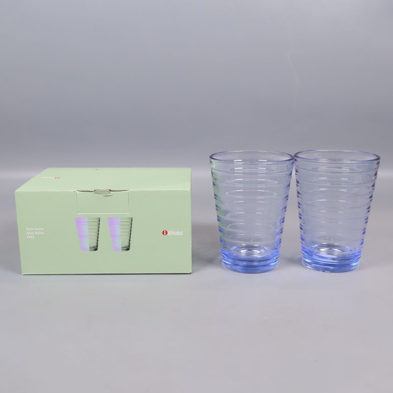 Två blå glas och Iittala-förpackning på grå bakgrund