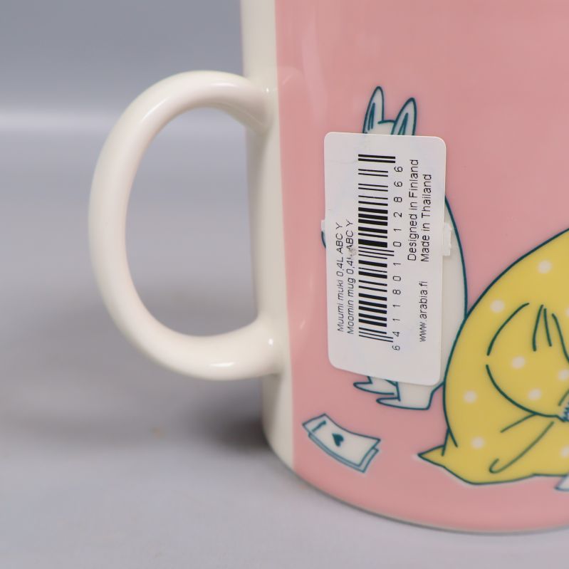 Närbild på Muminmuggens handtag och streckkodsetikett