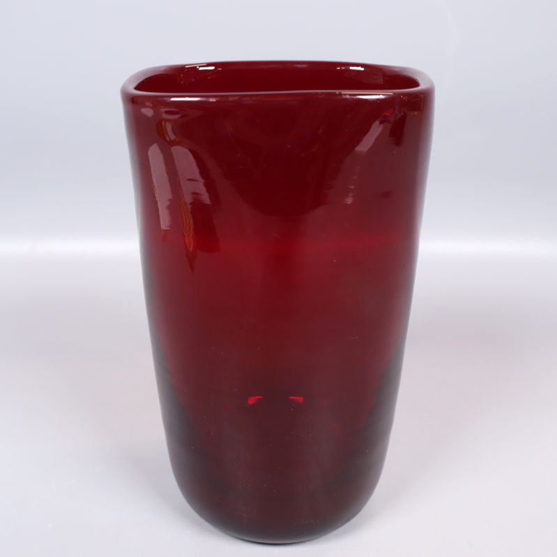 Röd glasvas i modern design fotograferad framifrån