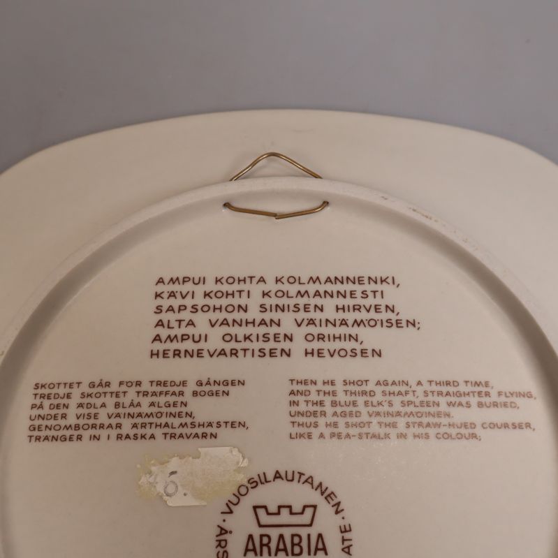 Närbild av text och stämpel på tallrikens baksida