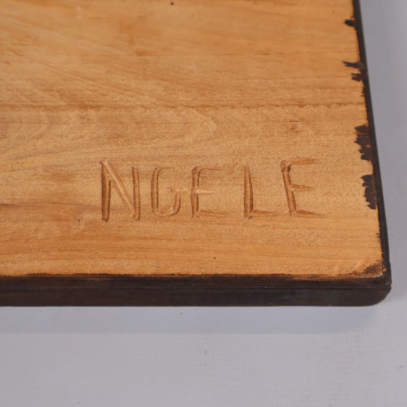 Närbild på signaturen NGELE på baksidan av trärelief