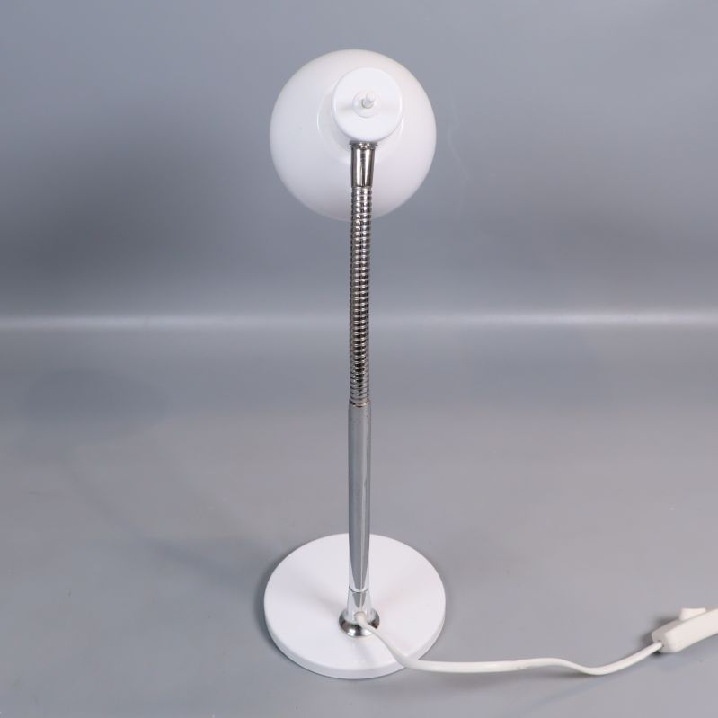 Bordslampa sedd snett bakifrån med kromad arm