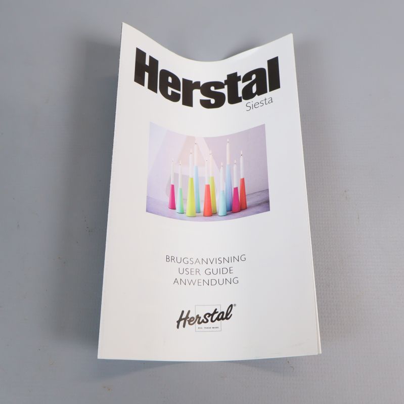Manual med Herstal-logotyp och ljusstakebild