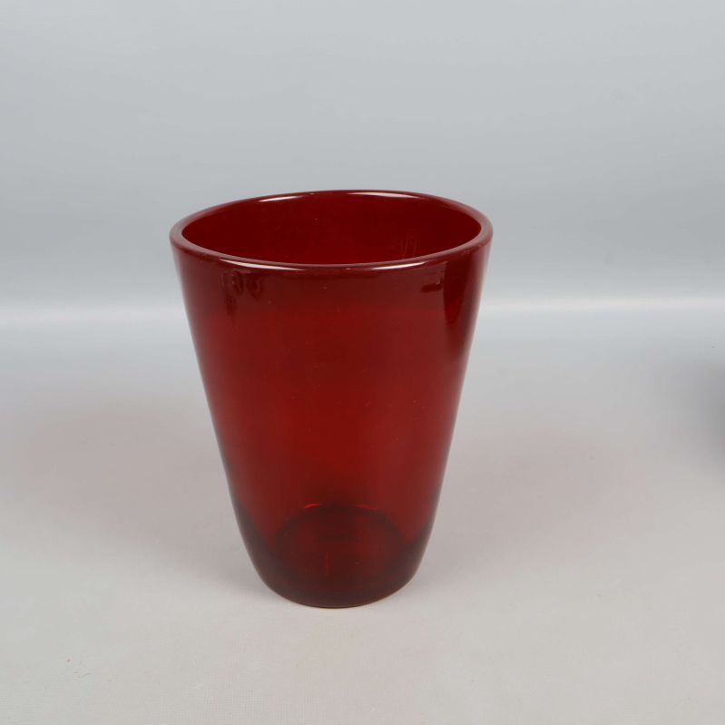 Röd glasvas stående med slät yta