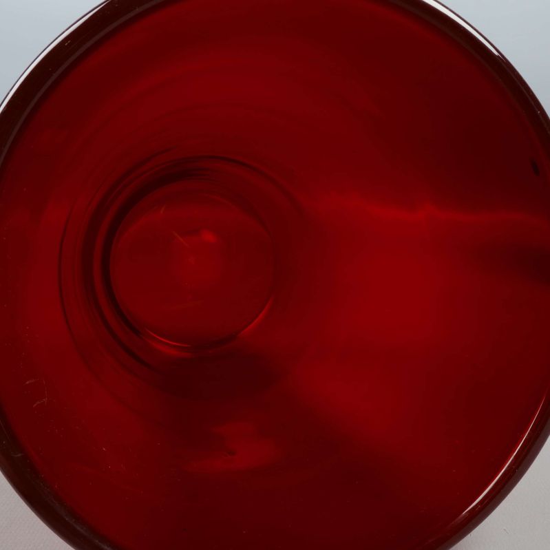 Närbild av vasens runda botten i rött glas