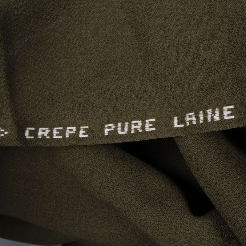 Texten 'CREPE PURE LAINE' på tygkanten