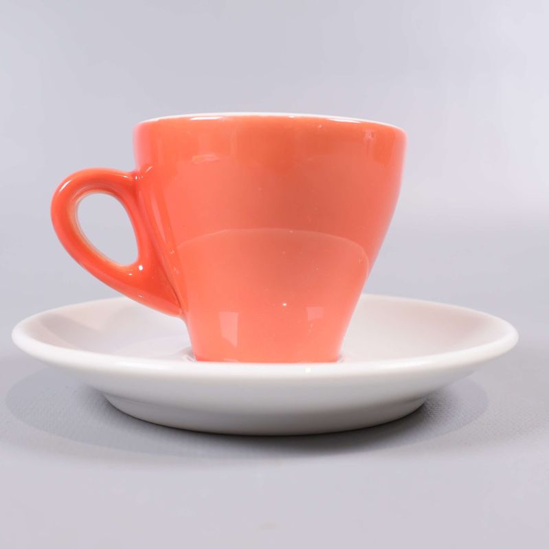 Närbild av orange espressokopp och vitt fat