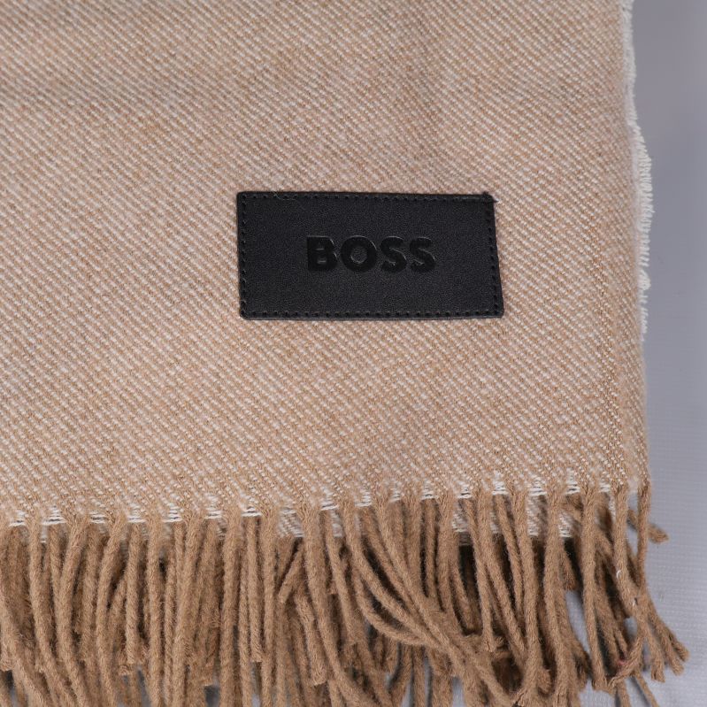 Närbild på BOSS label sytt på plädkant vid fransar