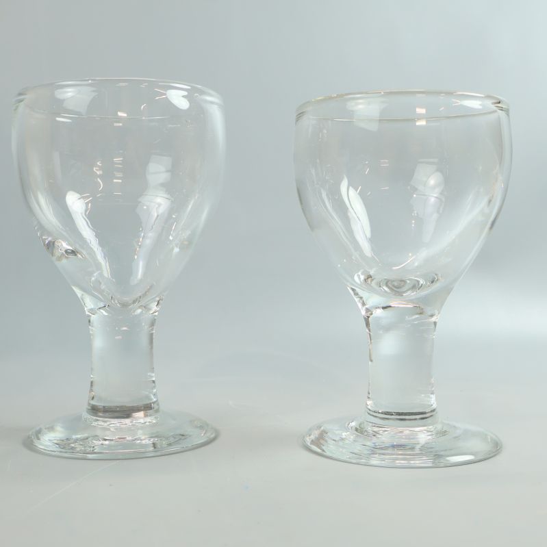 Närbild på två glas från sidan med ovanligt kupade former