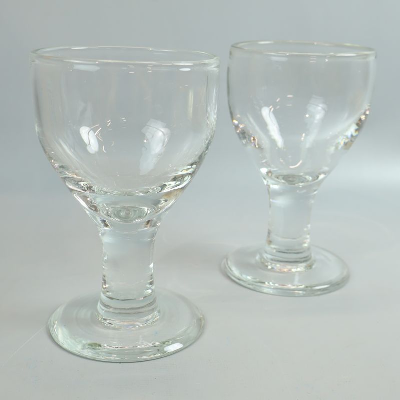 Två glas på fot i klart glas mot ljus bakgrund