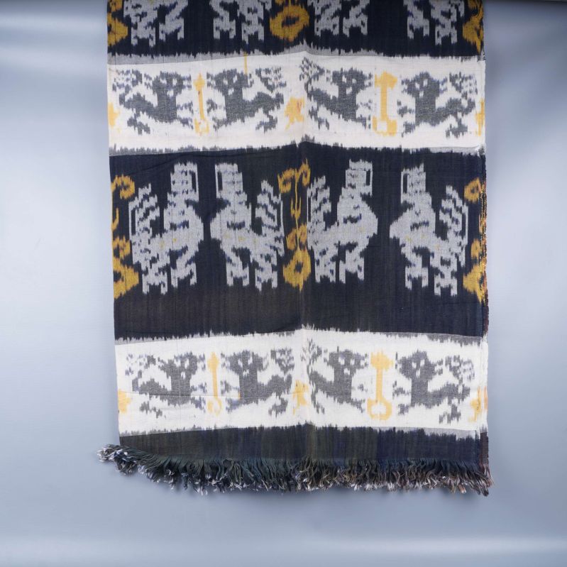 Framsida av textil med fransar och tydligt randigt mönster