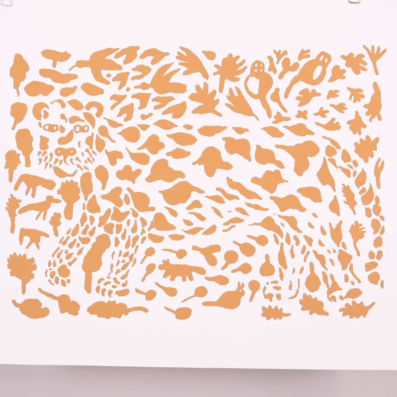 Närbild på konsttryck med aprikosfärgade detaljer och leopard