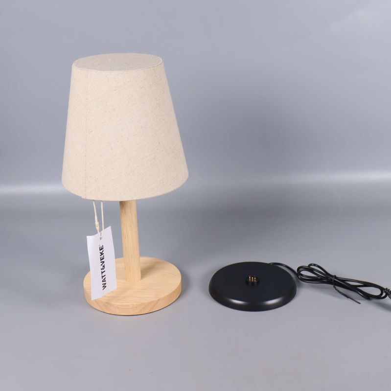 Bordslampa och svart rund lampfot med sladd på grå bakgrund