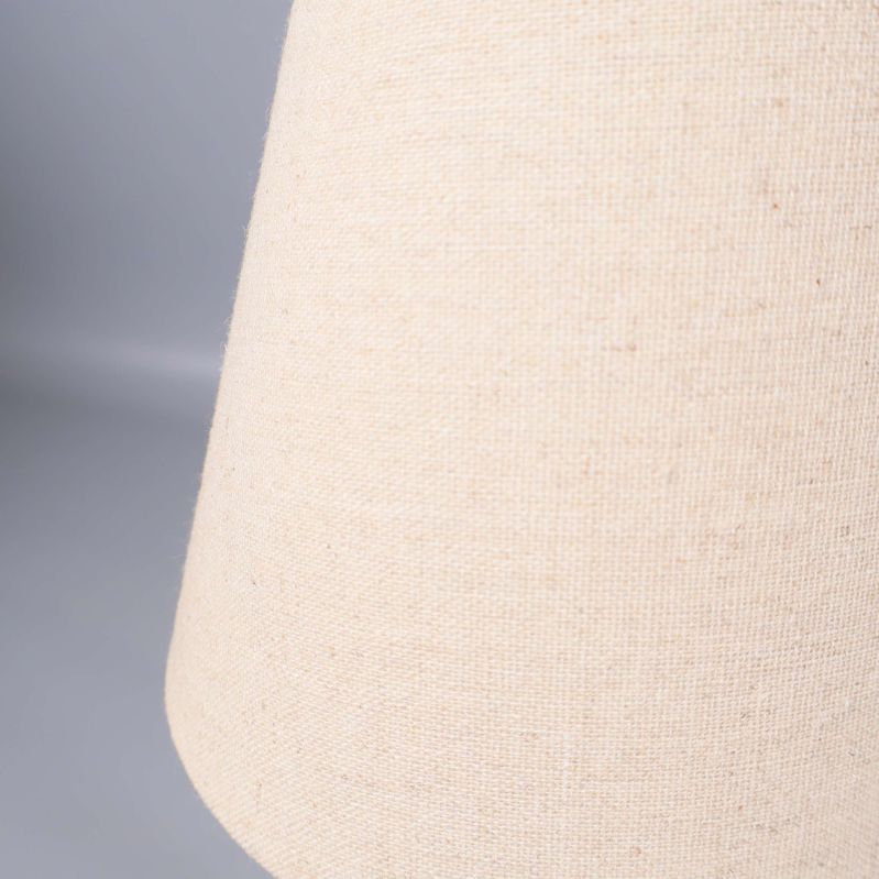 Närbild på beige textilmaterial i lampskärm