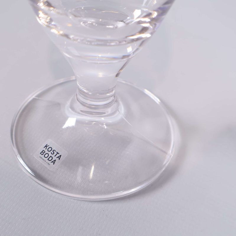 Fot på glas med Kosta Boda-etikett synlig