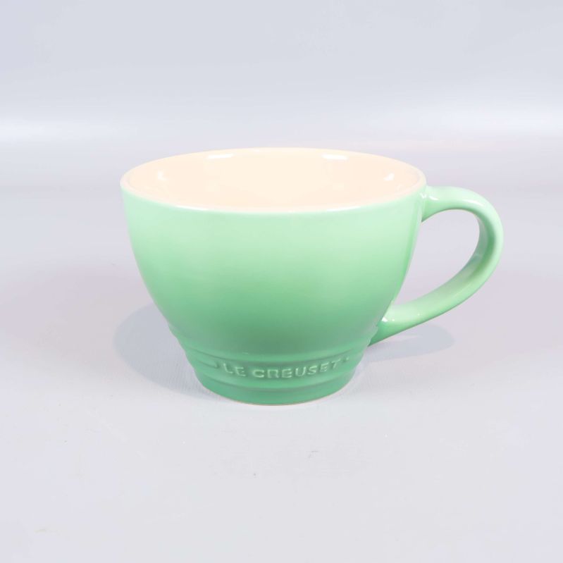 Mintgrön kopp med synlig Le Creuset-logga
