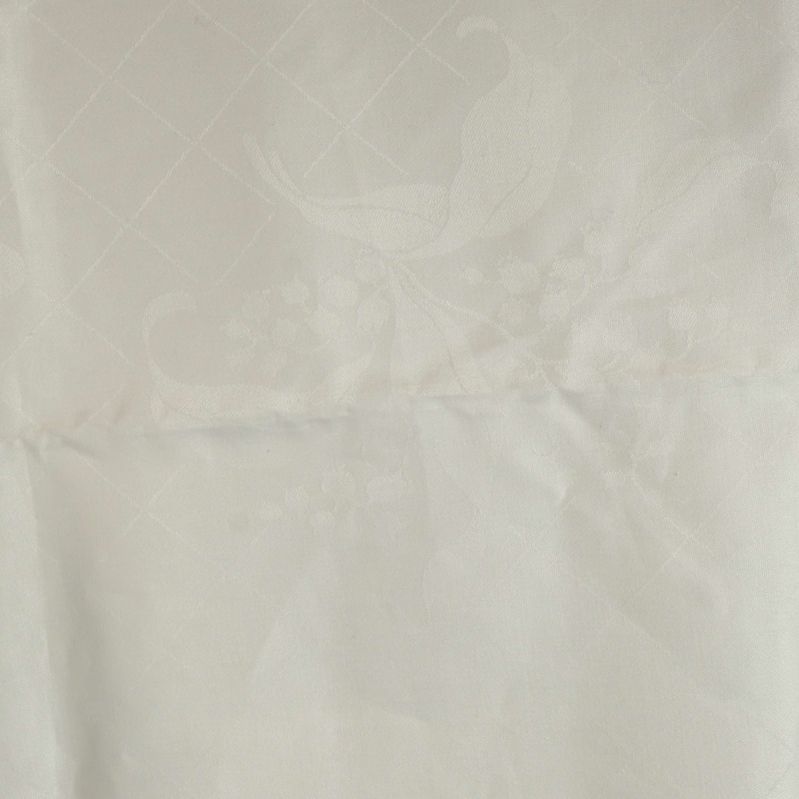 Närbild på vävt mönster i vit duk