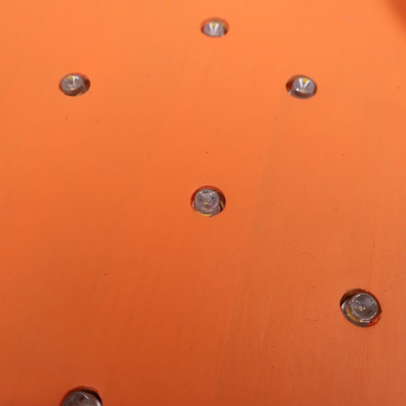 Närbild på orange yta med infällda LED-lampor