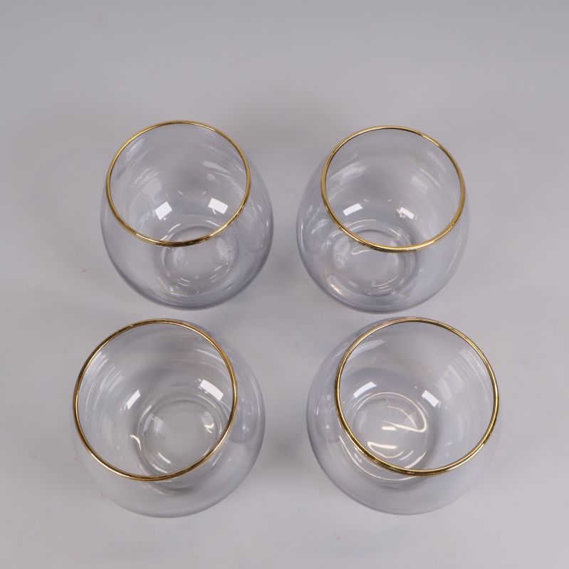 Överifrånvy på fyra glas med guldkant ordnade i kvadrat