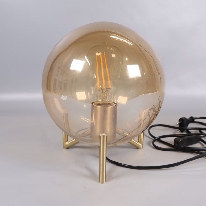 Detalj av glaskupa och synlig ljuskälla på bordslampa
