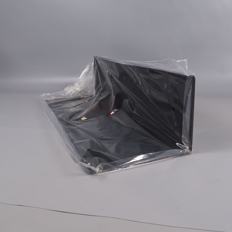 Svart vägglampa i plastförpackning på grå bakgrund
